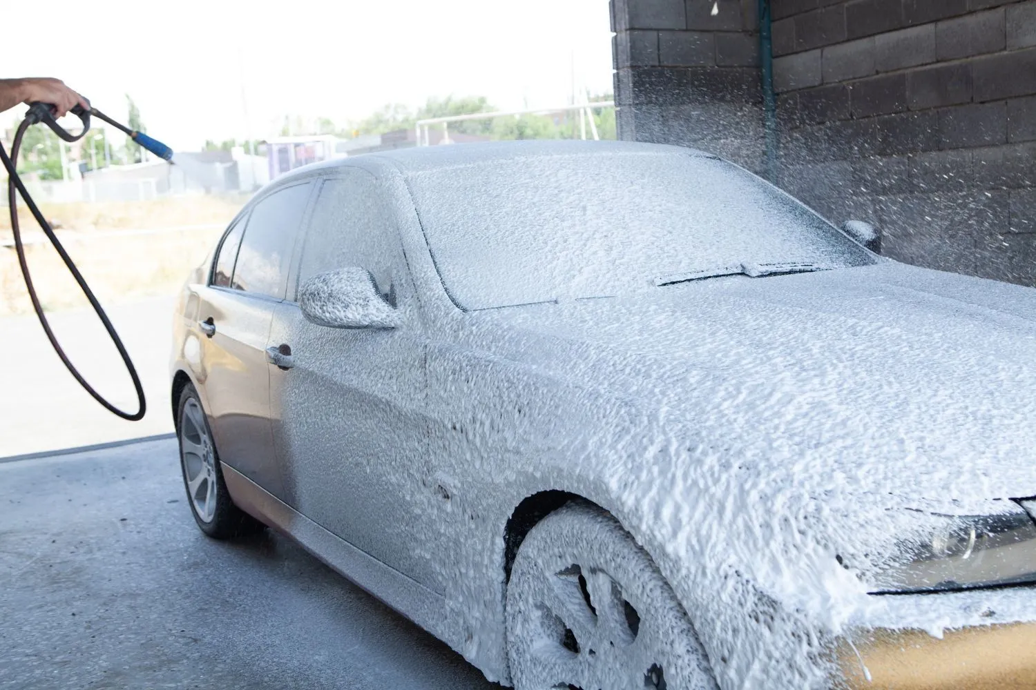 A car covered in cleaning foam at a wash