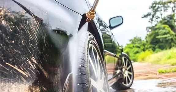 A car being rinsed with a high-pressure spray